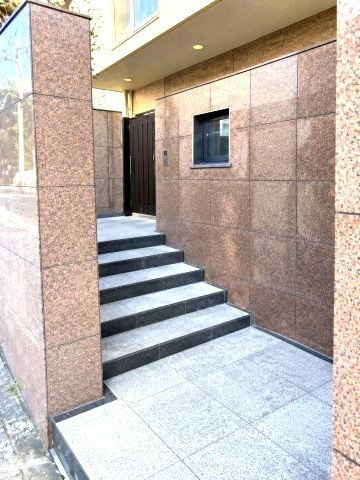 六甲篠原パークマンションの玄関|上質感漂う専用玄関へのアプローチ。居住者の帰り、訪れる方を優しく迎える・安らぎに満ちた生活空間を予感させる。健やかな暮らしを楽しめそう
