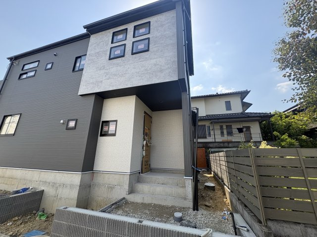 新築戸建　川西市清和台西1丁目の外観|外からの視線をさりげなく遮る、横向き（南向き）玄関。グレーのシックな外観が目を惹きます♪