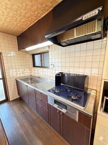花園東町2丁目中古戸建のキッチン|3口コンロ、グリル付きのシステムキッチンで快適にお料理できます！（室内写真は加工により家具等を消しています。）