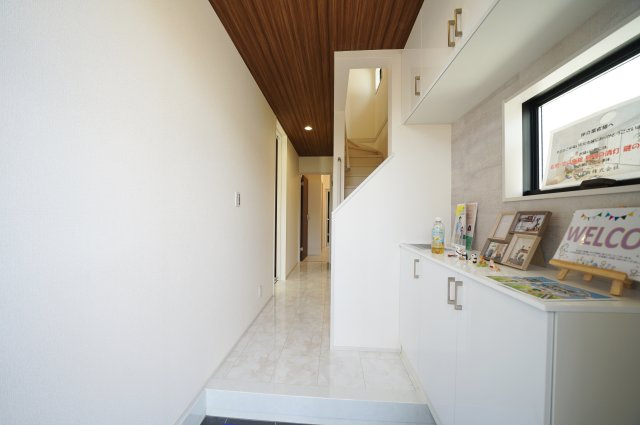 【横浜市南区永田台23-3全2棟新築戸建て】★仲介手数料無料★（永田台小学校・永田中学校）の玄関|木目調の折り上げ天井が印象的な玄関空間。上質感を演出しながら、豊富な収納で散らかりやすい玄関まわりもすっきり整います。