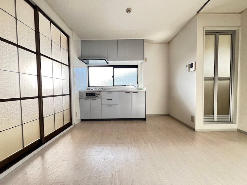 神戸市北区有野町唐櫃のハイツの居間・リビング|ダイニングキッチンは白を基調とした明るい空間です。
