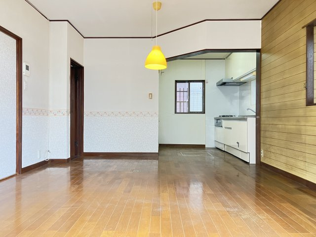 千葉県船橋市金杉７丁目　～２駅利用可。落ち着いた住宅街～の居間・リビング|照明が温かみを添える、木目調壁面のリビング。