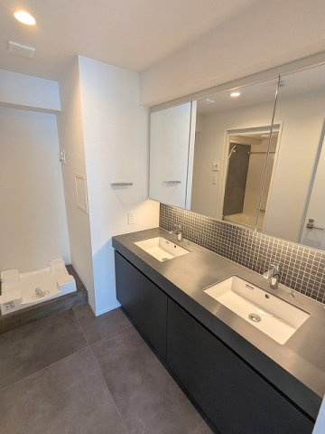 ライトハウス元浅草の洗面所|トイレと独立した洗面脱衣室、2ボウル、3面鏡付洗面台、洗濯機置場は排水口のお手入れしやすい様に手前中央に配置し、足高の防水パンです