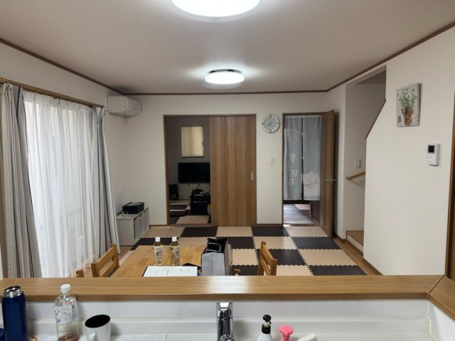 下川原六丁目戸建て物件の居間・リビング|キッチンからリビング側　マットは汚れ防止で置いてあり　実際はフローリグです