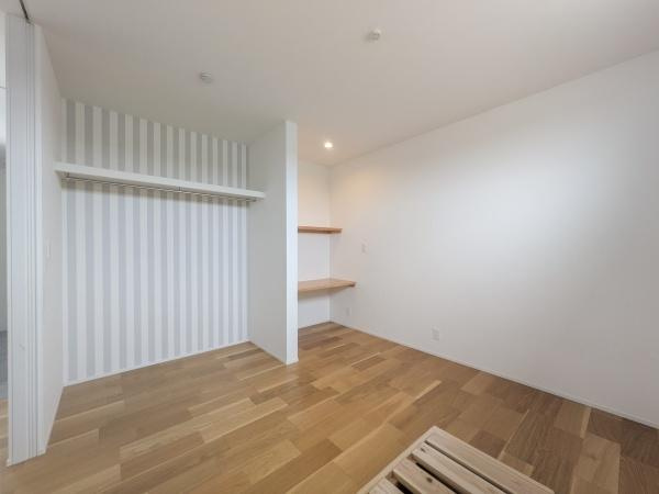 久原南2丁目　戸建て(美容室併設)の洋室|落ち着いた色合いのフローリングが特徴の洋室です。クローゼットスペースも確保され室内はすっきりとした印象です。壁面のストライプ柄がアクセントになっており明るい雰囲気を感じられます。