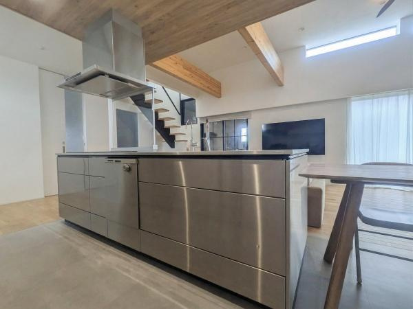 久原南2丁目　戸建て(美容室併設)のキッチン|スタイリッシュなデザインのキッチンが印象的です。
天井の木目とキッチンの金属素材が落ち着いた雰囲気を演出します。