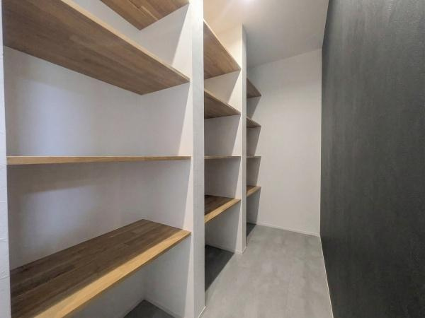 久原南2丁目　戸建て(美容室併設)の収納|棚板が多く設置されており効率的に物を収納できます。奥行きのあるスペースで使い勝手の良さが感じられます。収納のレイアウトも工夫されており日常使いに便利です。壁面のカラーが空間にアクセントを加えています。