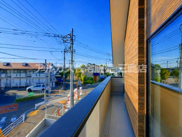 府中市南町2丁目　京王線　分倍河原駅　新築戸建のバルコニー|青空が広がる見晴らしの良いバルコニーです。木目調の外壁がナチュラルな印象を与え、洗濯物を干す際やちょっとしたリフレッシュ空間としても快適に活用できます。