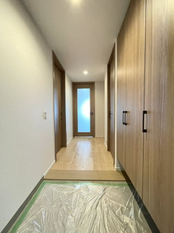 グランディム京都烏丸五条の玄関|木目調で統一された温かみのある玄関。大容量のシューズボックスを備え、すっきりとした空間を保てます。