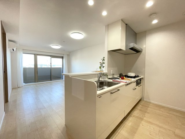 グランディム京都烏丸五条の居間・リビング|LDKを見渡せる開放的な対面キッチン。大きな窓からたっぷりと陽光が差し込む明るい空間です。