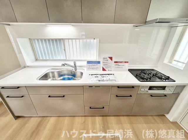 中古戸建　川西市美山台3丁目のキッチン|三口コンロとグリルでの同時調理で時短＆効率アップ♪キッチン前に窓があり、お料理中の換気もバッチリ♪