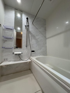 【浴室】 | 朝霞市膝折町3丁目 | 大理石調のアクセントパネルが高級感を演出するバスルーム。雨の日の衣類乾燥や、冬場の暖房に大活躍する浴室暖房乾燥機を完備しています 。築浅ならではの清潔感溢れる空間で、日々の疲れを癒せます。