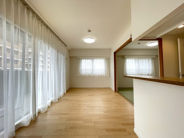 玄関ポーチがあるコトによってプライバシー得やすい角部屋に。オープンタイプの和室も使い勝手が良さそうで、うたた寝注意の『ナイスサンソレイユ横濱鶴ヶ峰』リノベーションの居間・リビング|ゆったりとした居間です