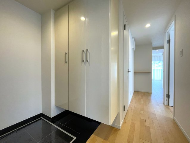 玄関ポーチがあるコトによってプライバシー得やすい角部屋に。オープンタイプの和室も使い勝手が良さそうで、うたた寝注意の『ナイスサンソレイユ横濱鶴ヶ峰』リノベーションの玄関|明るい玄関です