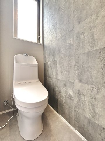豊橋市西新町のトイレ|落ち着いたグレーのアクセントクロスがおしゃれな空間。
窓付きで明るく換気もしやすく、清潔感のあるトイレになります！