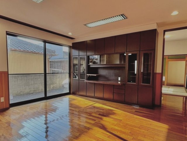 豊橋市王ヶ崎町字宮脇の居間・リビング|大きな窓から光が差し込む明るいリビングです。造り付けの収納棚があり、テレビ周りもスッキリまとまります。和室とつながる開放的な空間で、ゆったりくつろげるお部屋になります。