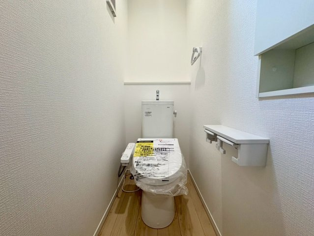 「利便性MAX」高知市南金田第1　2号棟新築一戸建てのトイレ|温水洗浄便座付きの清潔感あふれるトイレ。便利な2連ペーパーホルダーや小物を置ける棚も備わっています。