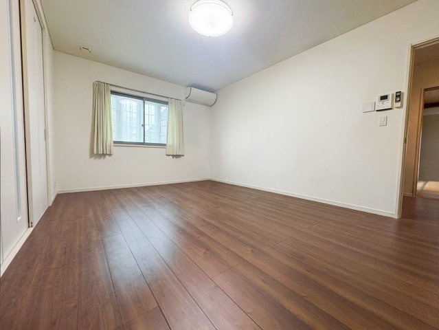 宗像市池田 中古戸建の居間・リビング|引き戸を開放して、広々と使えるLDK！
（※AI加工により家具・荷物を消去しています）