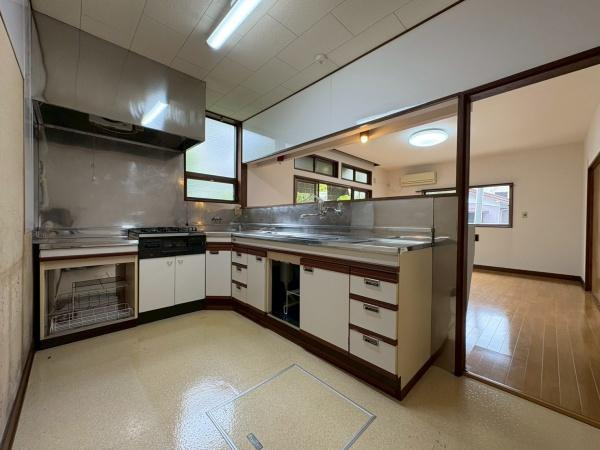 鎌倉市植木の中古一戸建のキッチン|キッチンからリビングが見渡せる開放的な空間です。収納が豊富で調理器具や食器の整理に便利です。換気扇と窓があり明るさと通風にも配慮されています。床下収納も備わっています。