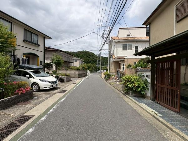 鎌倉市植木の中古一戸建の前面道路含む現地写真|前面道路は幅員がしっかり確保されており車の出入りもスムーズに行いやすい環境です。両側には住宅が並び整然とした街並みが広がっています。周辺は落ち着いた雰囲気で道路沿いには緑も感じられます。