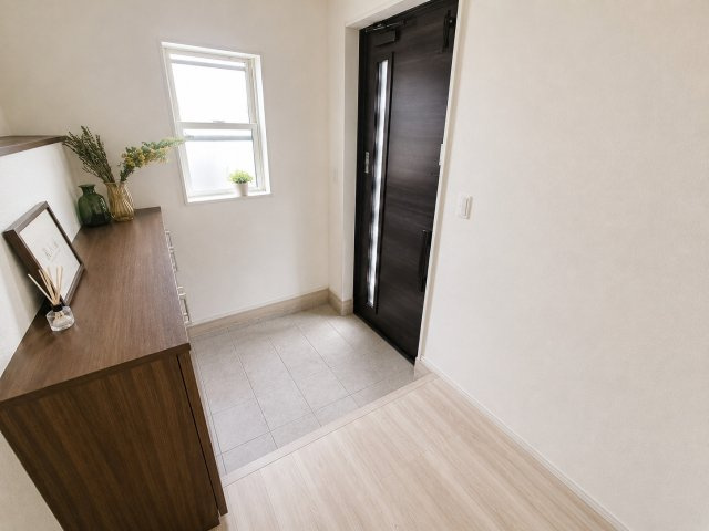 前橋市青柳町 中古住宅の玄関|明るい窓から自然光が差し込む開放感ある玄関。ゆとりある広さで、家族みんなが快適に使える空間です。シューズ収納も充実し、すっきりとした玄関を保てます。