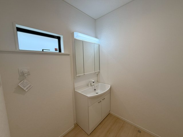 クレイドルガーデン糸満市南波平 第２・３号棟の独立洗面台|ハンドシャワー付き洗面化粧台＆洗濯機置場／洗面室に窓