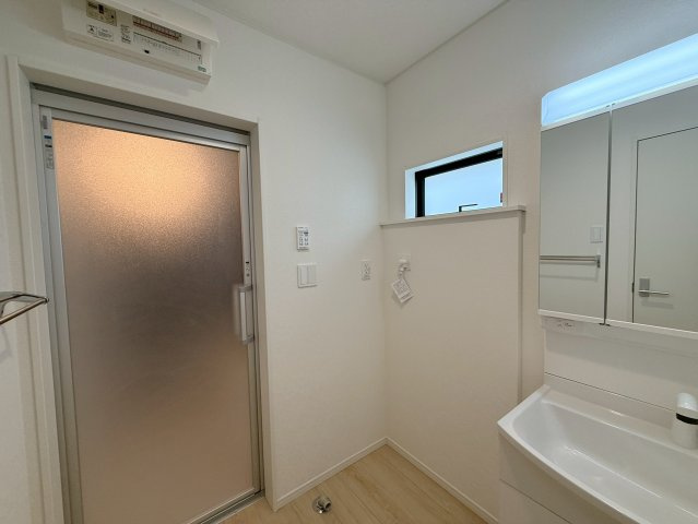 クレイドルガーデン糸満市南波平 第２・３号棟の独立洗面台|ハンドシャワー付き洗面化粧台＆洗濯機置場から浴室への動線