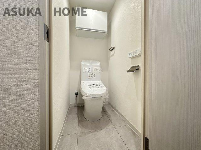 横浜東本郷マンションのトイレ|温水洗浄便座の最新トイレ設備。奥行きの有るトイレスペース、吊戸棚があり収納も◎
