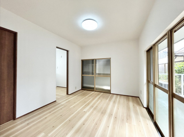 「全居室6帖以上」高知市北竹島町　中古一戸建ての洋室|1階洋室。扉を開ければ広々空間、閉めれば個室になる柔軟な間取り。