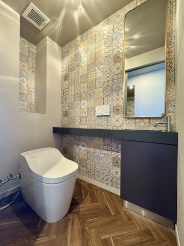 セントラルガーデンのトイレ|トイレはタンクレストイレで、手洗い器と鏡も一緒に併設されております。ちょっとした物置スペースも便利ですね。