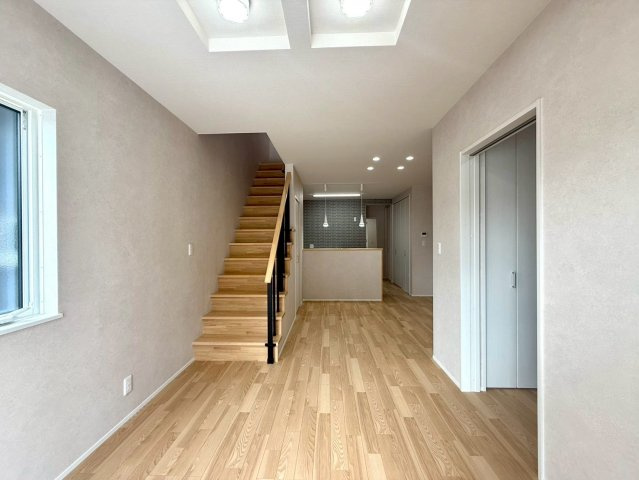 「イオンモールすぐ」高知市秦南町2丁目　新築住宅の玄関|朝の光が心地よく差し込むリビング。階段越しに家族の気配を感じられる空間設計です。