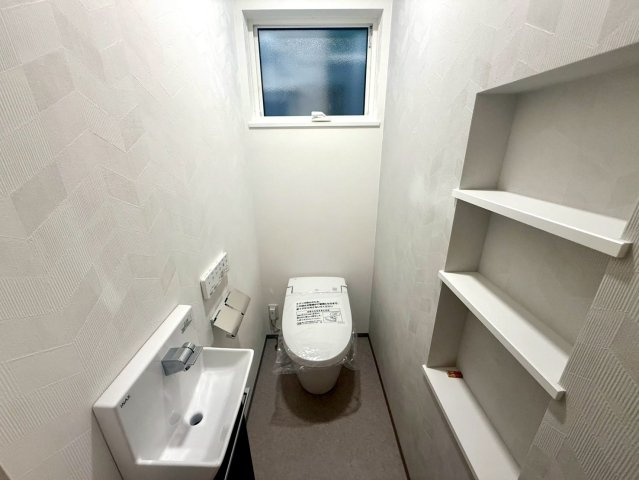 「イオンモールすぐ」高知市秦南町2丁目　新築住宅のトイレ|収納棚付きで使いやすく、生活感を抑えたすっきり空間。