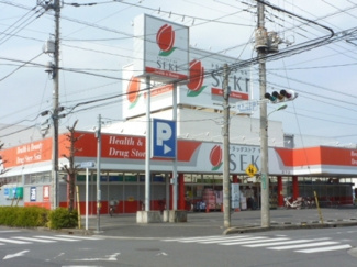 ドラッグストアセキ 芝下店まで700ｍ