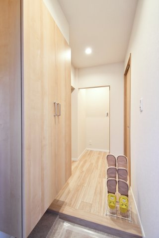 浦和辻第２住宅の玄関|玄関から居室へと続く、質感豊かなフローリングが奥行きを演出。ダウンライトの柔らかな光が、リフォーム済みの美しい室内を照らします。扉を開けた瞬間に広がる開放的な住まいを、ぜひ現地でご体感ください。