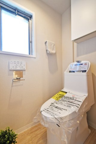 浦和辻第２住宅のトイレ|温水洗浄便座一体型トイレへ新規交換。清潔感のあるトイレです！戸棚がついておりますので備品補充も楽々行えます。白基調で窓からの光も感じられる圧迫感を感じにくい空間です。