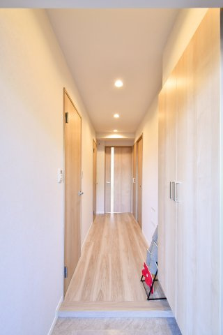 日商岩井北浦和マンションＢ棟の玄関|玄関から居室へと続く、質感豊かなフローリングが奥行きを演出。ダウンライトの柔らかな光が、リフォーム済みの美しい室内を照らします。扉を開けた瞬間に広がる開放的な住まいを、ぜひ現地でご体感ください。