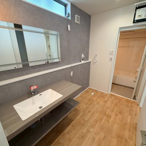 空港通７丁目　新築戸建　3LDKの独立洗面台|すっきりとした洗面空間は、毎朝の忙しい時間帯でも身支度が落ち着いてスムーズに整い、お洗濯の動線もフラットで無駄がないため、毎日の家事をテキパキと笑顔で片付けられる。