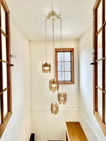 緑苑台東2条1丁目戸建の玄関|吹抜けとデザイン性の高い照明が付いた玄関スペースを２階から撮影