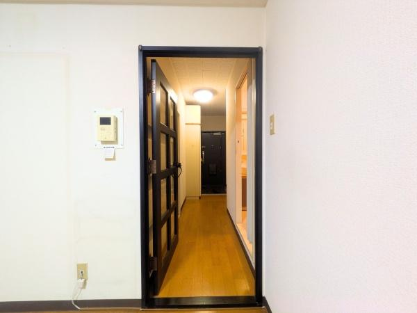 アーバン田室第二期棟の内装|明るい廊下が奥まで続いておりスペースにゆとりを感じられます。シンプルなデザインのドアが空間に調和しています。照明の工夫で全体がしっかりと照らされています。壁面もすっきりと整理されています。