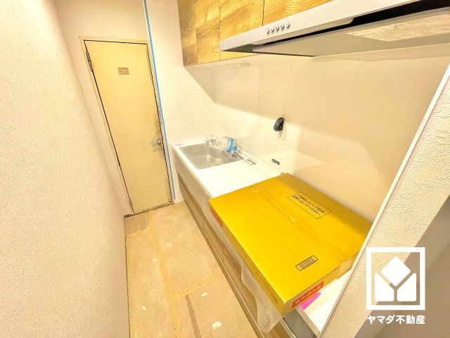 進和苦楽園アーバンライフB棟のキッチン|使いやすさとデザイン性を両立。落ち着いた木目調のデザインが魅力のシステムキッチンです。独立型なので生活感が出にくく、リビングの美観を損ねません。（リフォーム中の写真です）