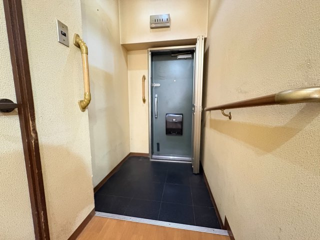 【商談中】サンハイム長岡京　の玄関|玄関には手すりが設置されており、靴の脱ぎ履きや外出時の動作をサポートしてくれます。