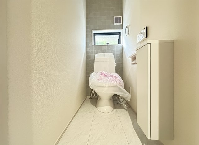 【トイレ】 | 志木市中宗岡1丁目　新築一戸建住宅　全1棟　(丸井志木店) | トイレは家族を感染症から守る温水洗浄便座を完備。
衛生用品や掃除グッズの保管に便利な壁面収納付きです。