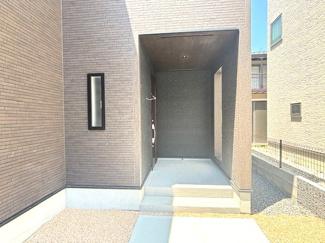 【玄関】 | 佐伯区美鈴が丘南4丁目【全1棟】 | 奥まった設計でプライバシーに配慮された玄関ポーチ。深い軒（インセット）があるため、雨の日でも濡れにくく落ち着いて鍵の出し入れが可能です。外壁のデザインと調和した、スタイリッシュな空間となっています。