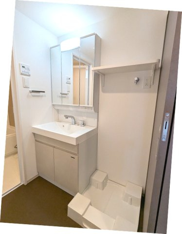エスレジデンス新御徒町chiaroの洗面所|トイレと独立した脱衣洗面室、三面鏡付ハンドシャワー付独立洗面台、洗濯機置場は排水口のお手入れをしやすく中央手前に配置し足高の防水パンです
