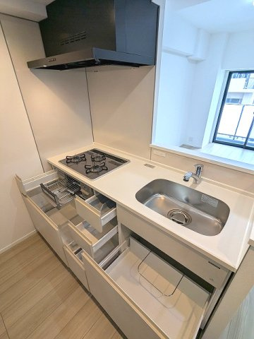 エスレジデンス新御徒町chiaroの設備|グリル付ガス3口システムカウンターキッチン、瀟洒でお手入れ楽なガラストップコンロ、収納は奥まで整頓しやすい手前にスライド式