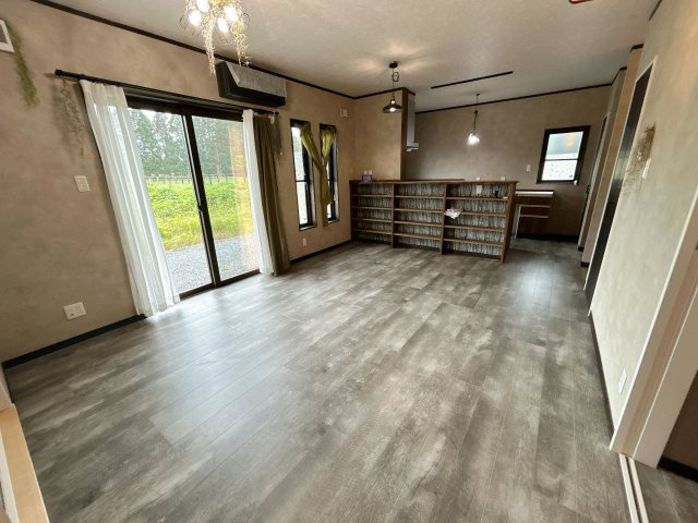 南相馬市鹿島区小池 築浅デザイナーズ平屋中古住宅 4LDK 陽当たり良好！ 不動産プラス の居間・リビング|リビング別角度です。19帖の広さがあり対面キッチンのLDKになっています。キッチンのリビング側には大容量の収納棚になっています。ディスプレ用の飾り棚としてもご利用いただけます。
