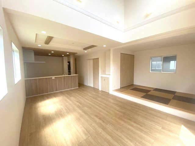 【ブルーミングガーデン】宇都宮市平松本町 全3棟の居間・リビング|〇1号棟　LDK18帖〇
キッチンのポップアップ天井にリビング折上天井、そして吹抜を採用し開放感あふれる空間が生まれました。ご家族が自然と集まりたくなる、そんな憩いの場です。
※2026年8月撮影