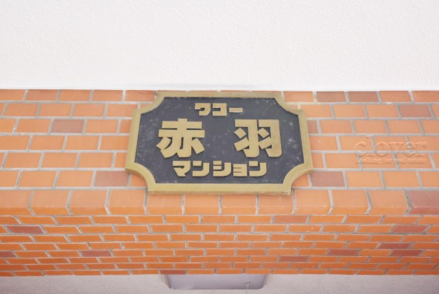 【現況写真】 | ワコー赤羽マンション | エントランスに掲げられた、マンション名を示す館銘板。さほど激しく主張はしませんが、しっかりと掲示されています。～即日のご見学可能～　お問合せはお気軽にどうぞ。

