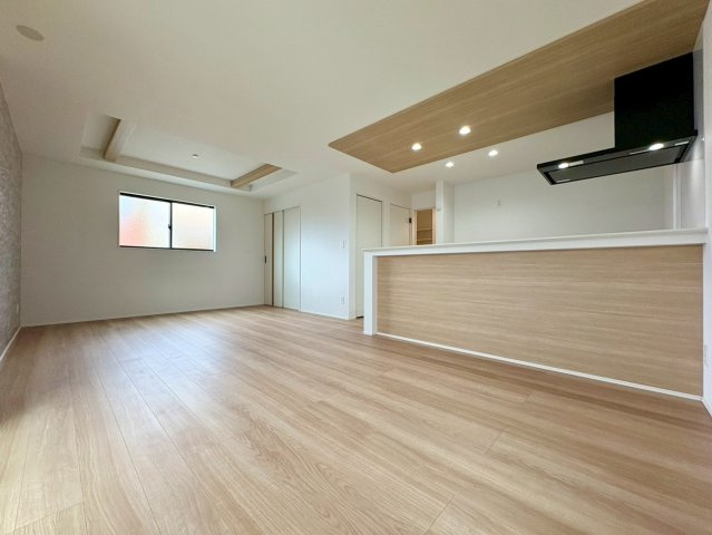「広々インナーバルコニー」高知市東城山町2号棟　新築一戸建ての居間・リビング|キッチンや折り上げ天井の木目が美しい空間。家族が自然と集まる明るいリビング。