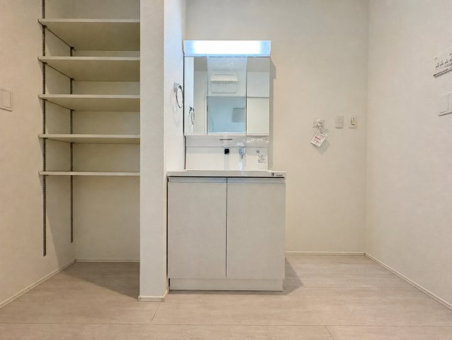 「広々インナーバルコニー」高知市東城山町2号棟　新築一戸建ての独立洗面台|三面鏡付き洗面台の横に大型の可動棚を配置。タオルや日用品もすっきり片付きます。